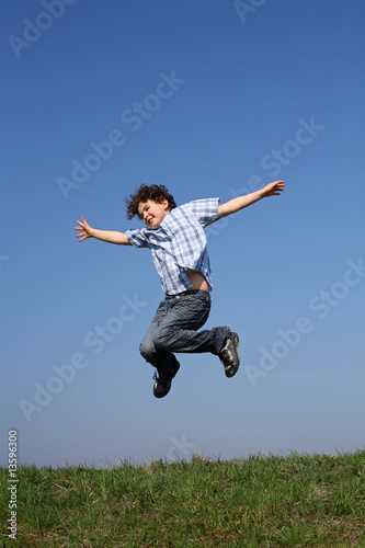 Boy jumping against blue sky