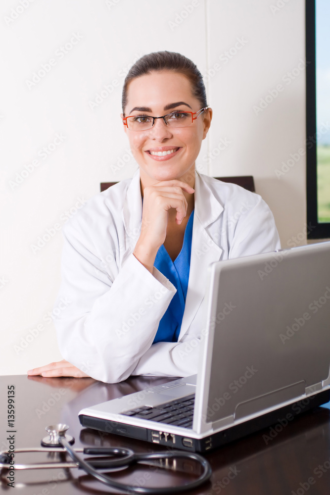 young female doctor sitting in front of laptop computer