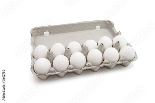 Twelve eggs in a paper box on white background