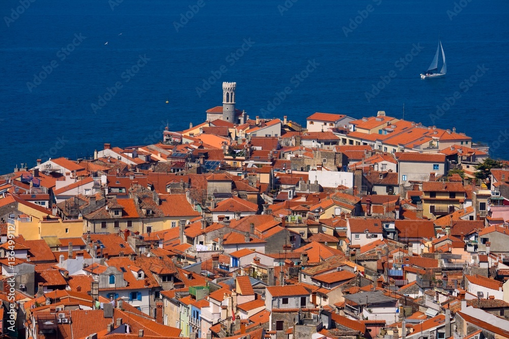 Roofs of a typical southern European town and a sailboat Roofs of a typical southern European town and a sailboat