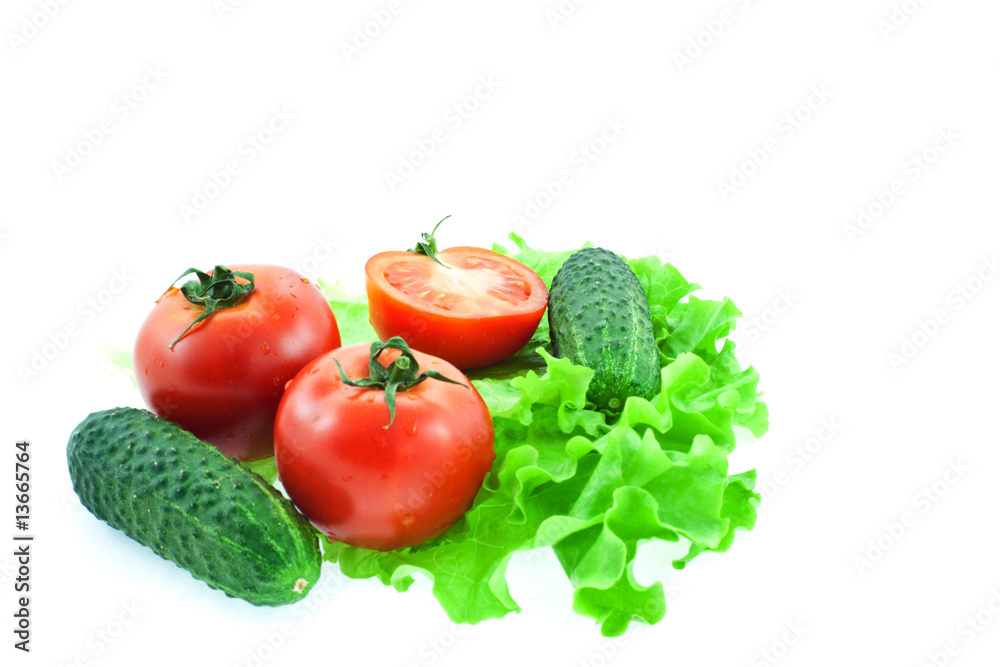 two and half tomatos and two cucumbers on leaves of lettuce two and half tomatos and two cucumbers on leaves of lettuce