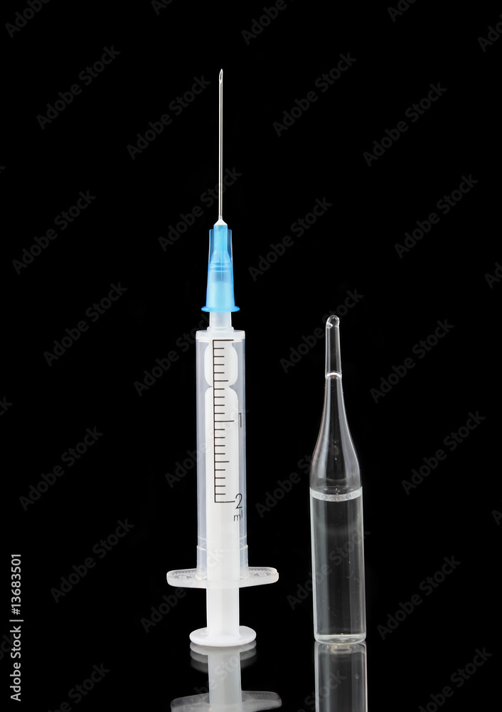 Syringe and ampule with medication on black background Syringe and ampule with medication on black background