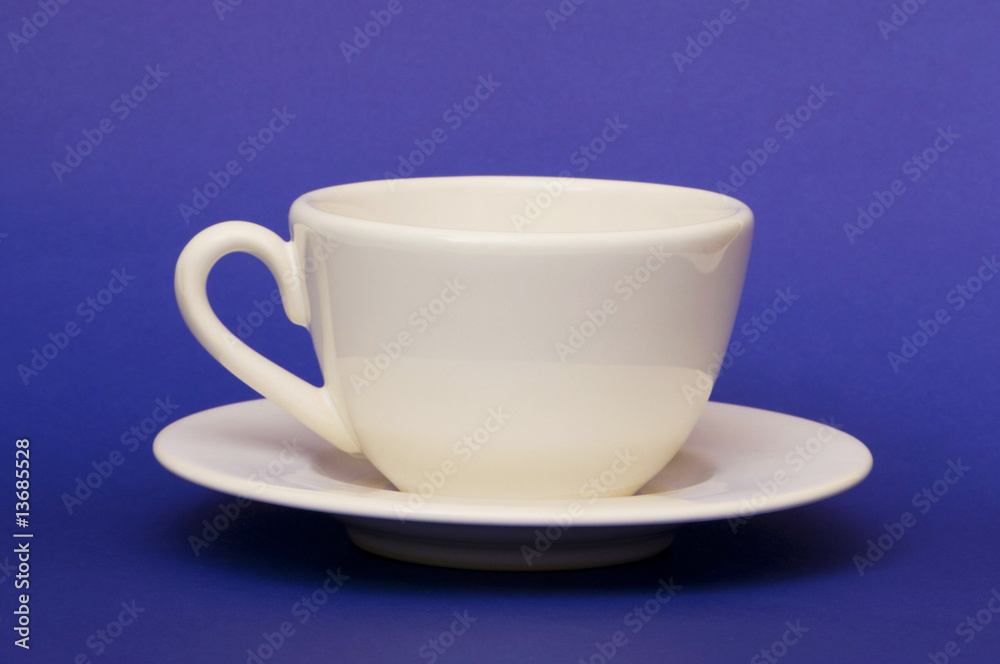 White cup isolated on the blue background White cup isolated on the blue background