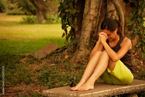 Hispanic woman praying outside