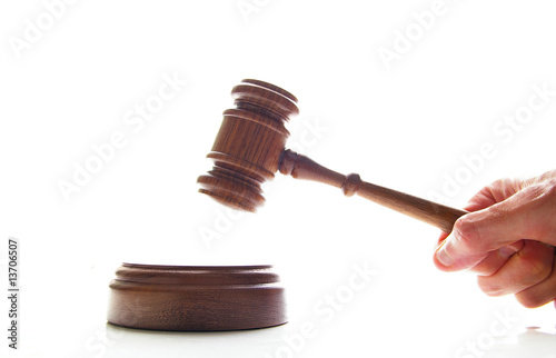 hand pounding a judges court gavel, isolated on white