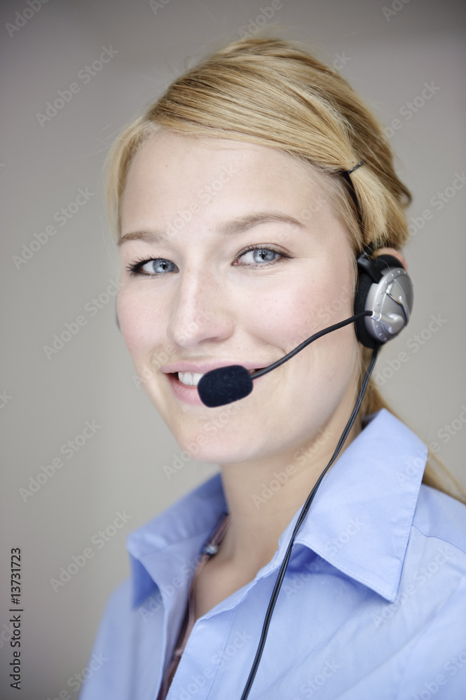 freundliche frau telefoniert mit headset in büro freundliche frau telefoniert mit headset in büro