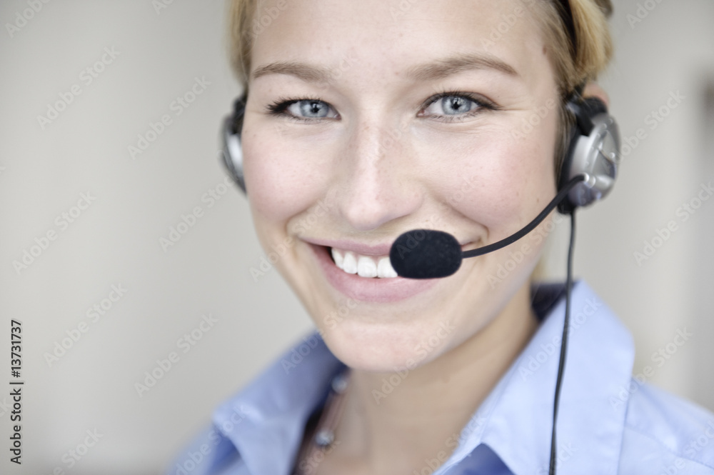 freundliche frau telefoniert mit headset in büro freundliche frau telefoniert mit headset in büro