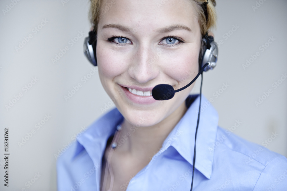 freundliche frau telefoniert mit headset in büro freundliche frau telefoniert mit headset in büro