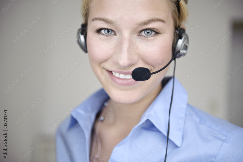 freundliche frau telefoniert mit headset in büro freundliche frau telefoniert mit headset in büro