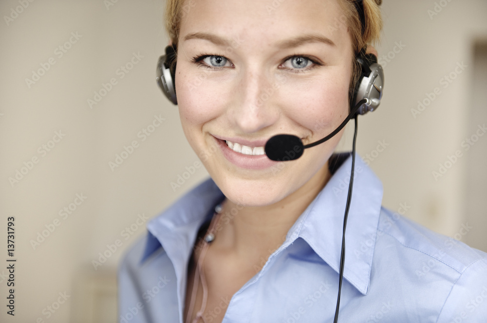 freundliche frau telefoniert mit headset in büro freundliche frau telefoniert mit headset in büro
