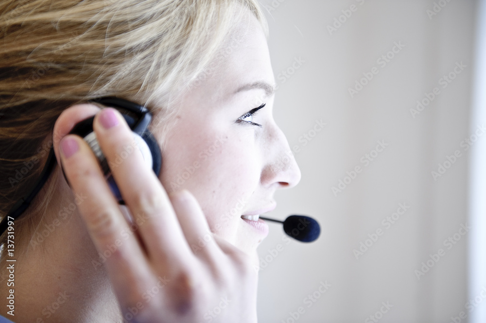 freundliche frau telefoniert mit headset in büro freundliche frau telefoniert mit headset in büro