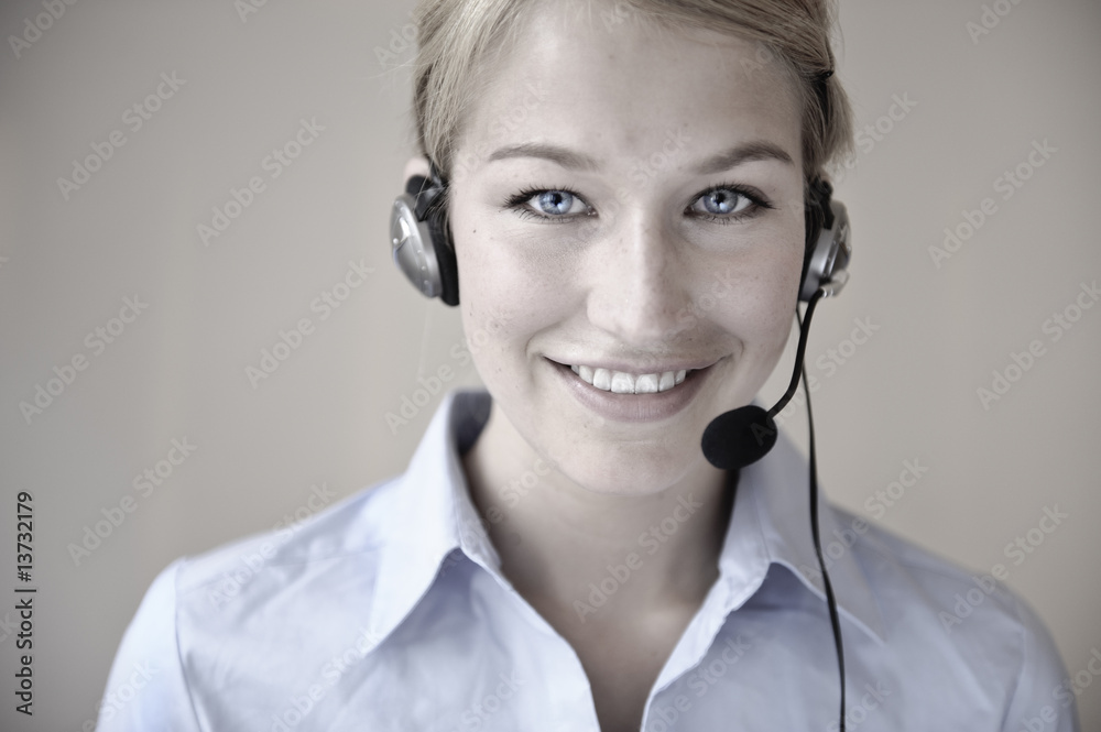 freundliche frau telefoniert mit headset in büro freundliche frau telefoniert mit headset in büro