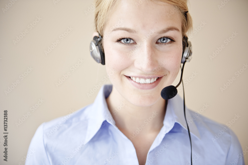 freundliche frau telefoniert mit headset in büro freundliche frau telefoniert mit headset in büro