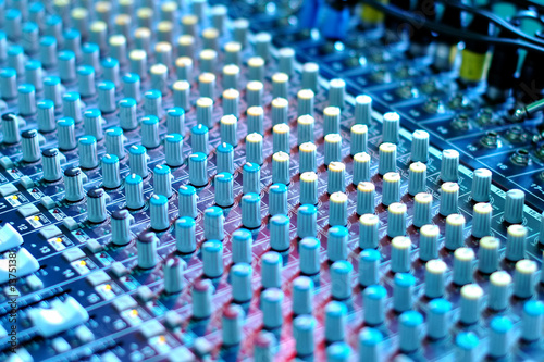 soundboard mixer under blue stage lighting