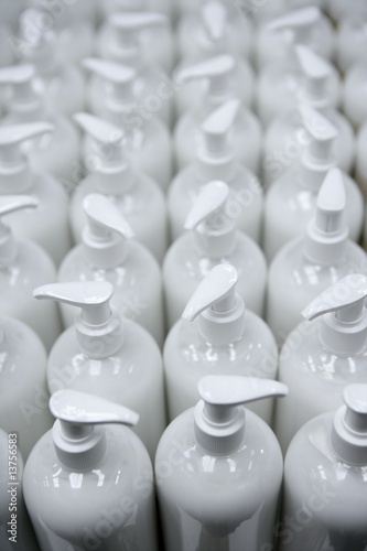 White plastic soap bottles in rows assembly line
