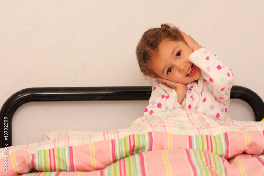 Happy girl holding head in bed