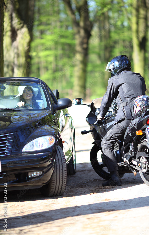 Fototapeta premium Sexy girl in car looking a man on a motorcycle