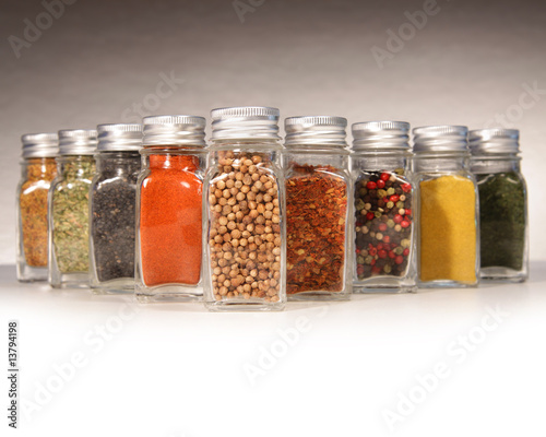 Bottles of colorful spices with grey