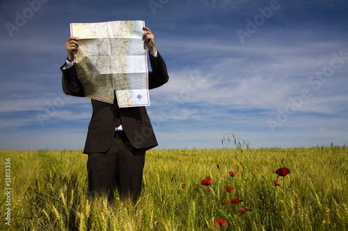 businessman lost in field using a map photo