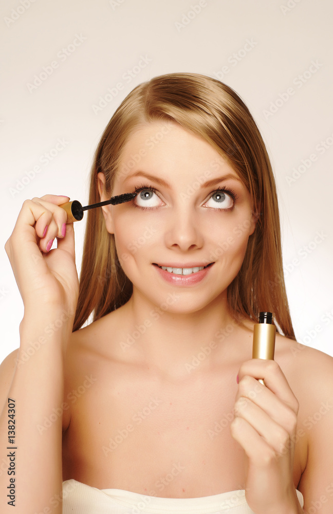 Pretty woman applying make up.