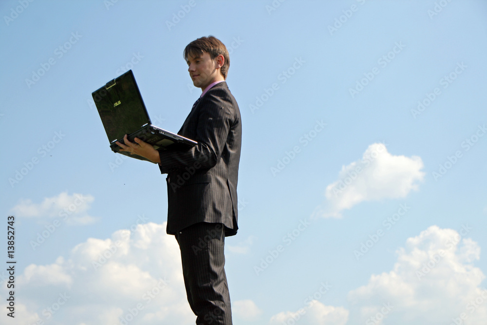 Businessman working with a laptop outdoor on a field