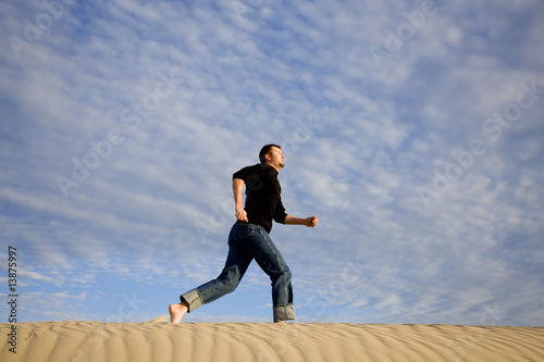 Man running in sand dunes