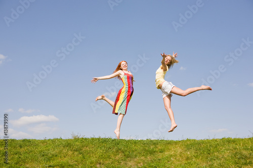 Two Happy young woman jumping