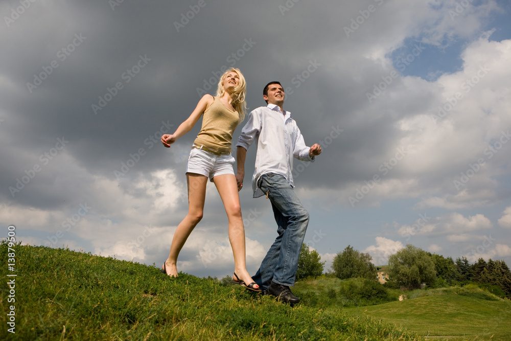 Young couple walking through summer lawn Young couple walking through summer lawn