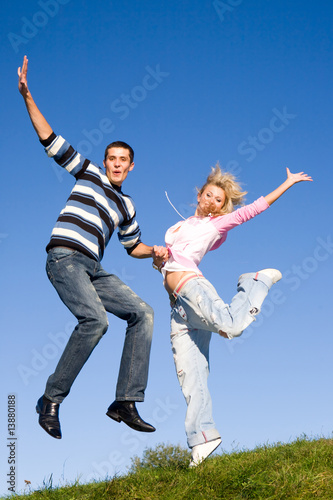 Happy Young love Couple - jumping under blue sky