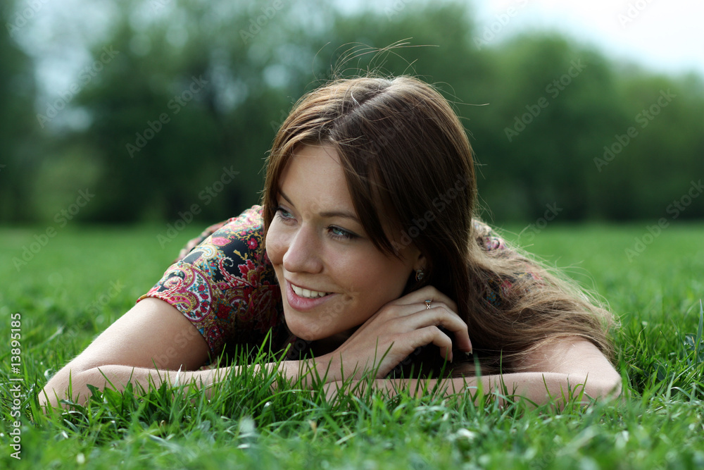 Young beautiful woman lays on green field Young beautiful woman lays on green field