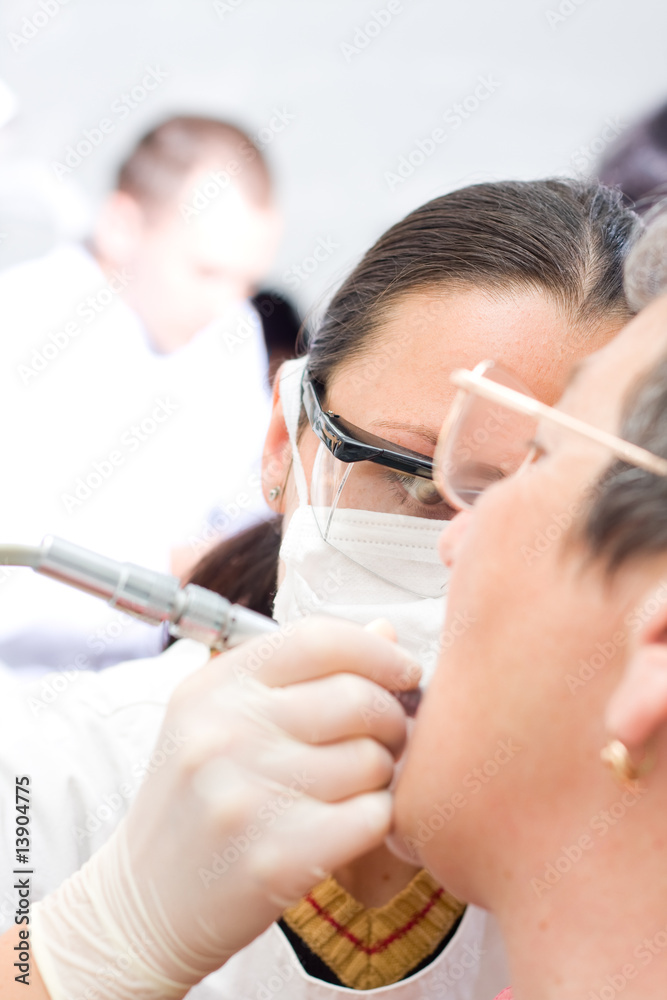 A young dentist treating an old woman's teeth - a series. A young dentist treating an old woman's teeth - a series.