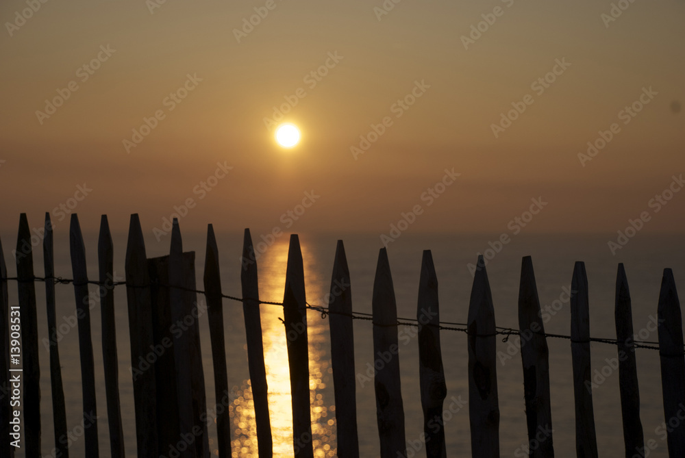 Coucher de soleil derrière clôture