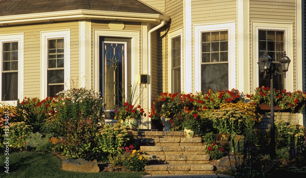 The front entrance of a house with a flower garden