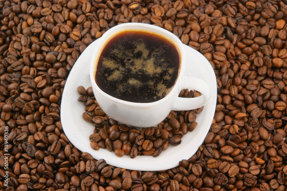 Fototapeta premium White cup of coffee on coffee grains background