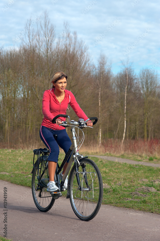 Woman cycling in a park.