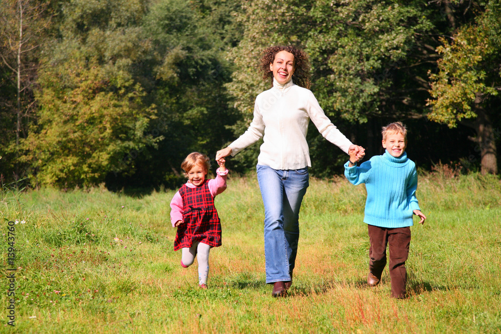 Obraz premium Matka z dziećmi biegnie w drewnie, widok z przodu