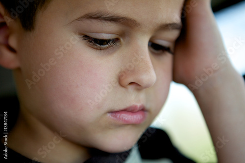 Sad little boy contemplating life