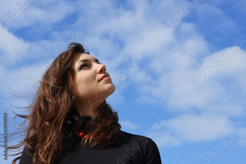 Beautiful young woman looking into the sky