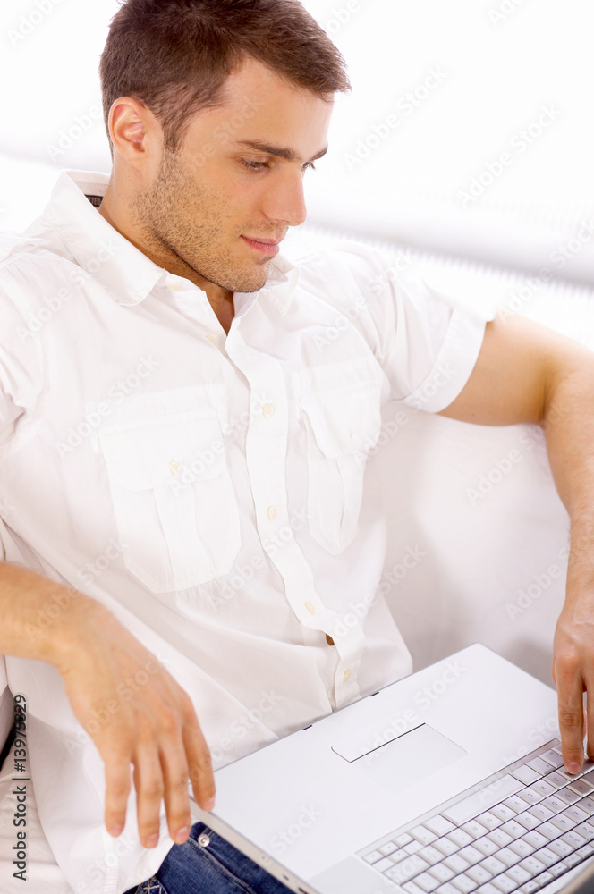 Young woman sitting on couch and working on laptop Young woman sitting on couch and working on laptop