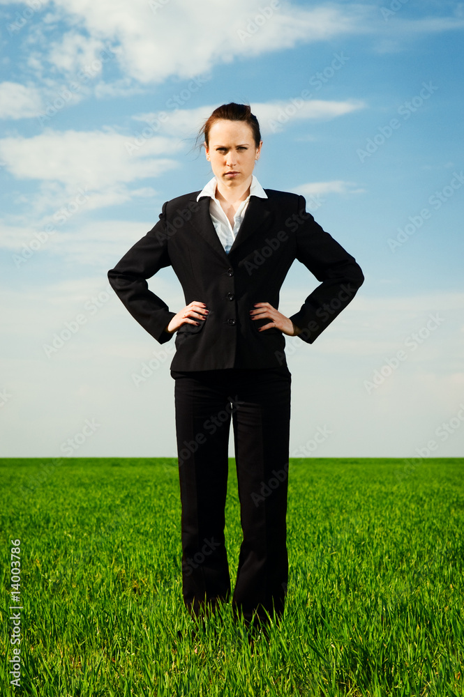 serious woman standing at the green field serious woman standing at the green field