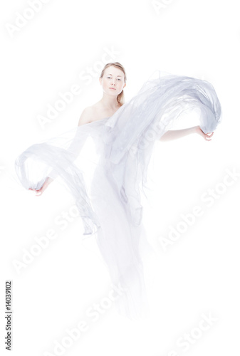 Young woman waving by light fabric over white high key