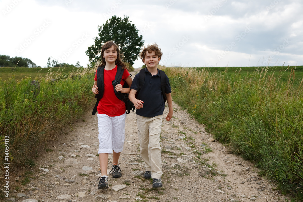 Girl and boy going to school in rural scenery