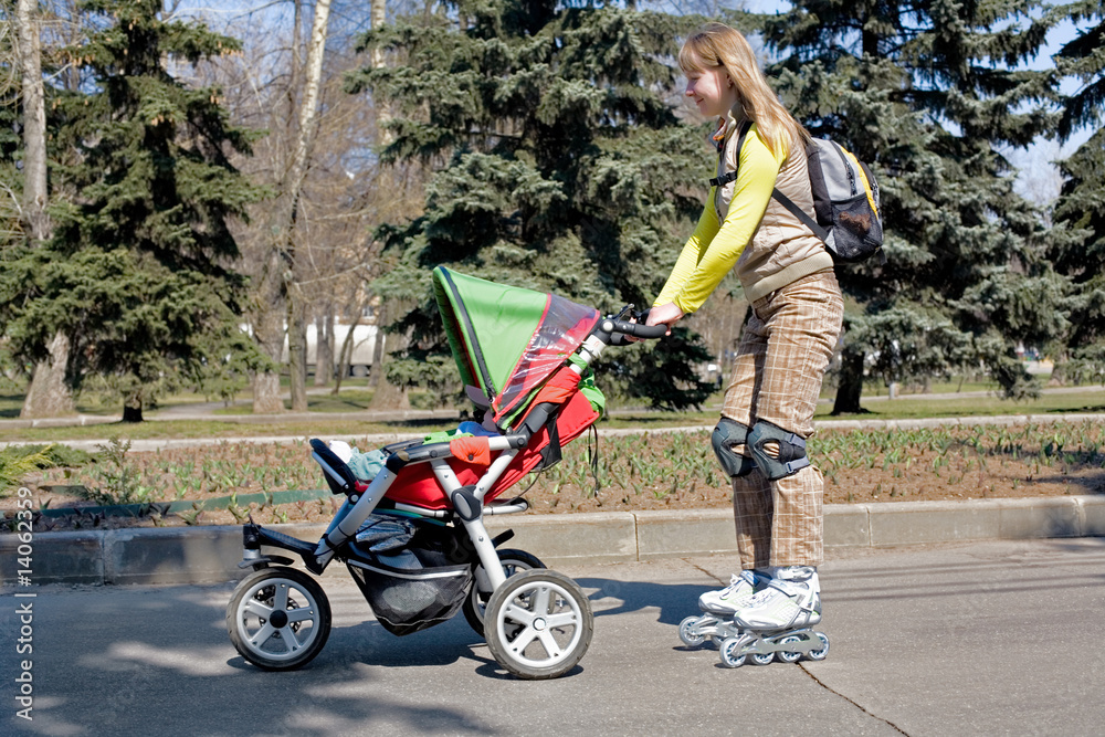 Young mother on roller skates with baby carriage