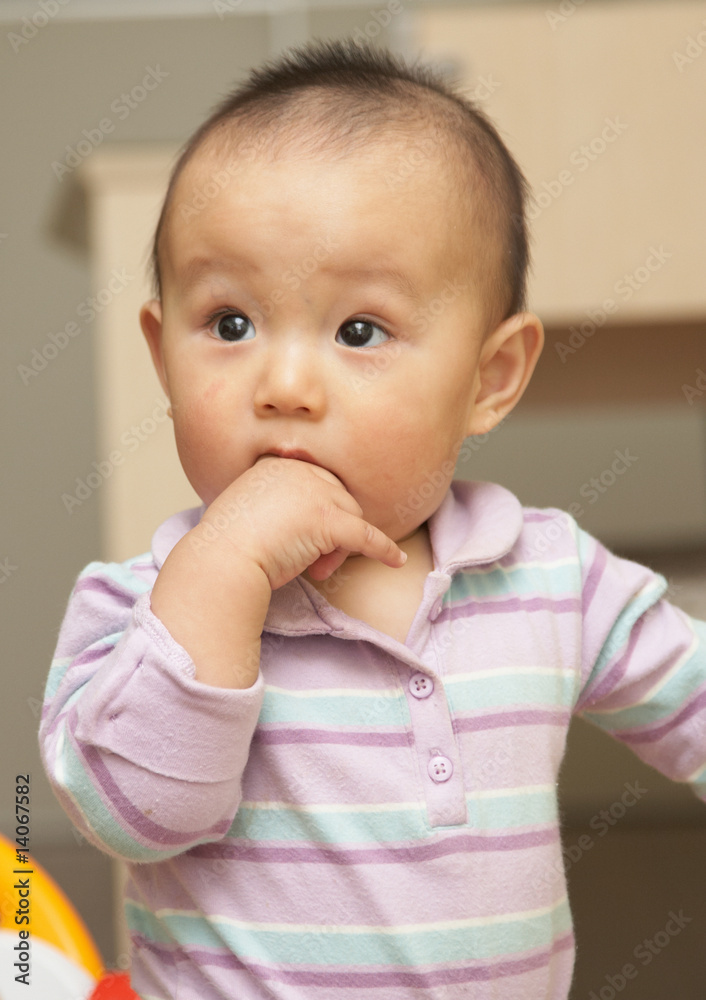 asian baby put his hand into mouth,looking curious. asian baby put his hand into mouth,looking curious.