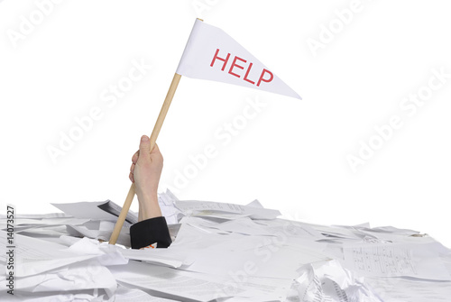 hand with help flag sticking out of desk full of paper