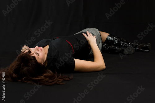 Young sexy woman lie on black.