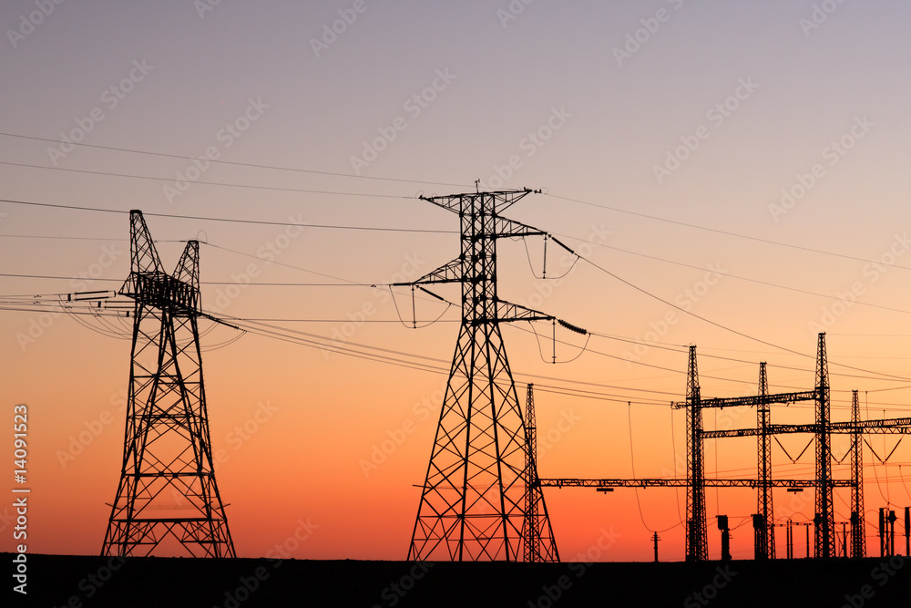 Fototapeta Silhouetted power pylons against a red sky at sunset