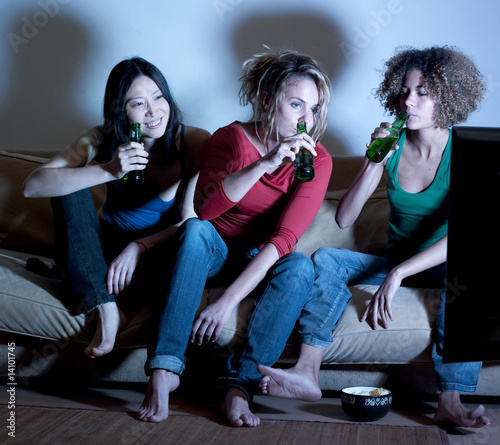 jeunes femmes buvant une bière devant la télé
