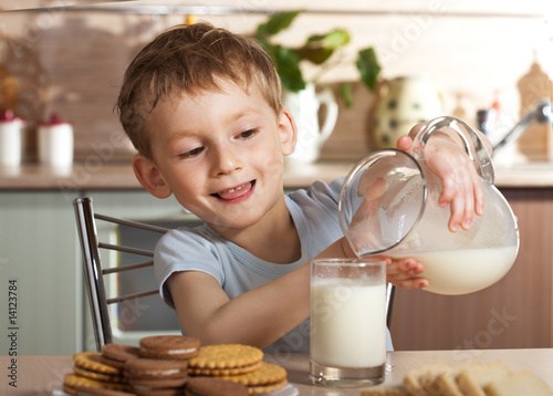 Healthy child pours milk from jug