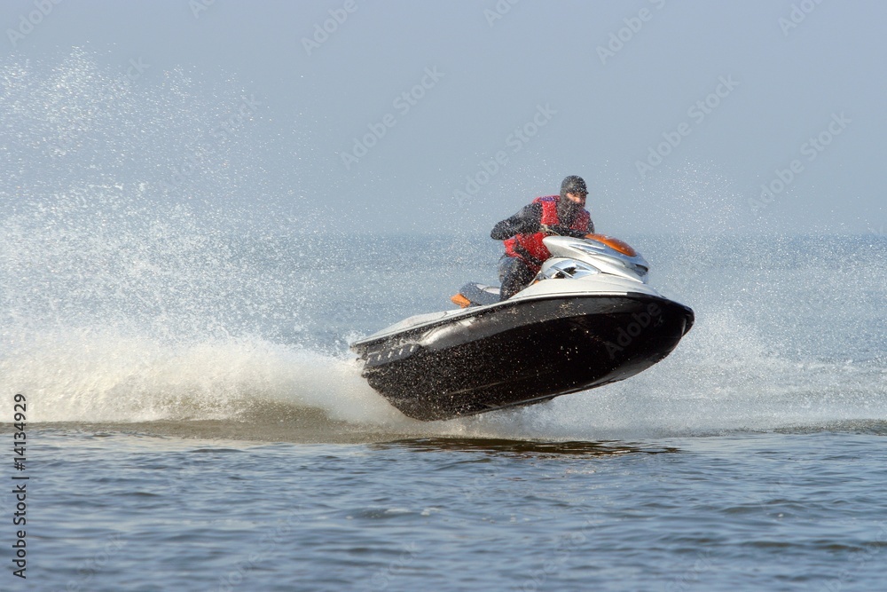 Fototapeta premium Jet ski in action with water spray on the blue sea